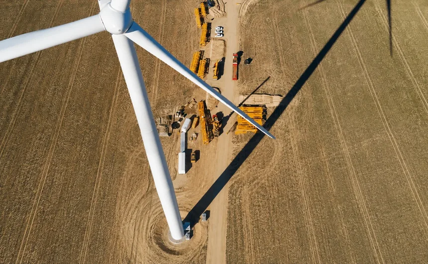 Aerial view of maintenance equipment around a wind turbine in an agricultural field